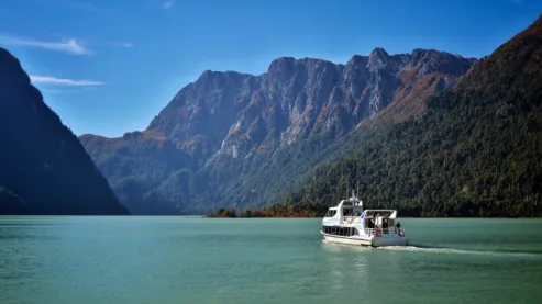 Barco blanco en aguas verdes del lago Frías. Es el fin del paso de las nubes