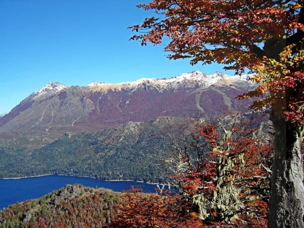 paisaje de otoño con un lago visto desde una montaña y un cerro al fondo